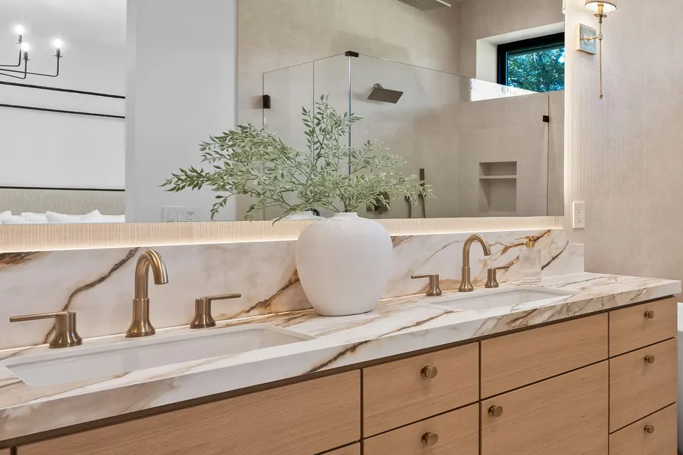 Double vanity with two sinks, with a glass shower reflected in the mirror, after the work