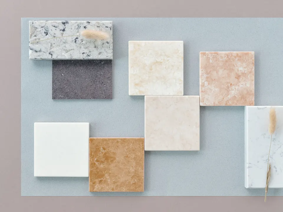 Stone and quartz samples laid out on a grey board
